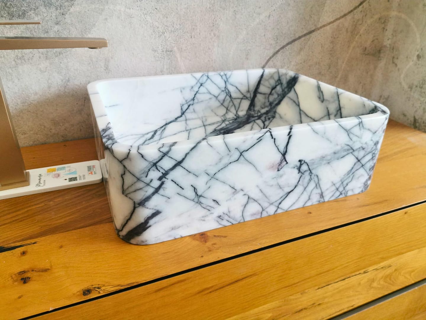 Lavabo da appoggio in marmo Lilac, con marcato movimento naturale delle venature grigie e nere.