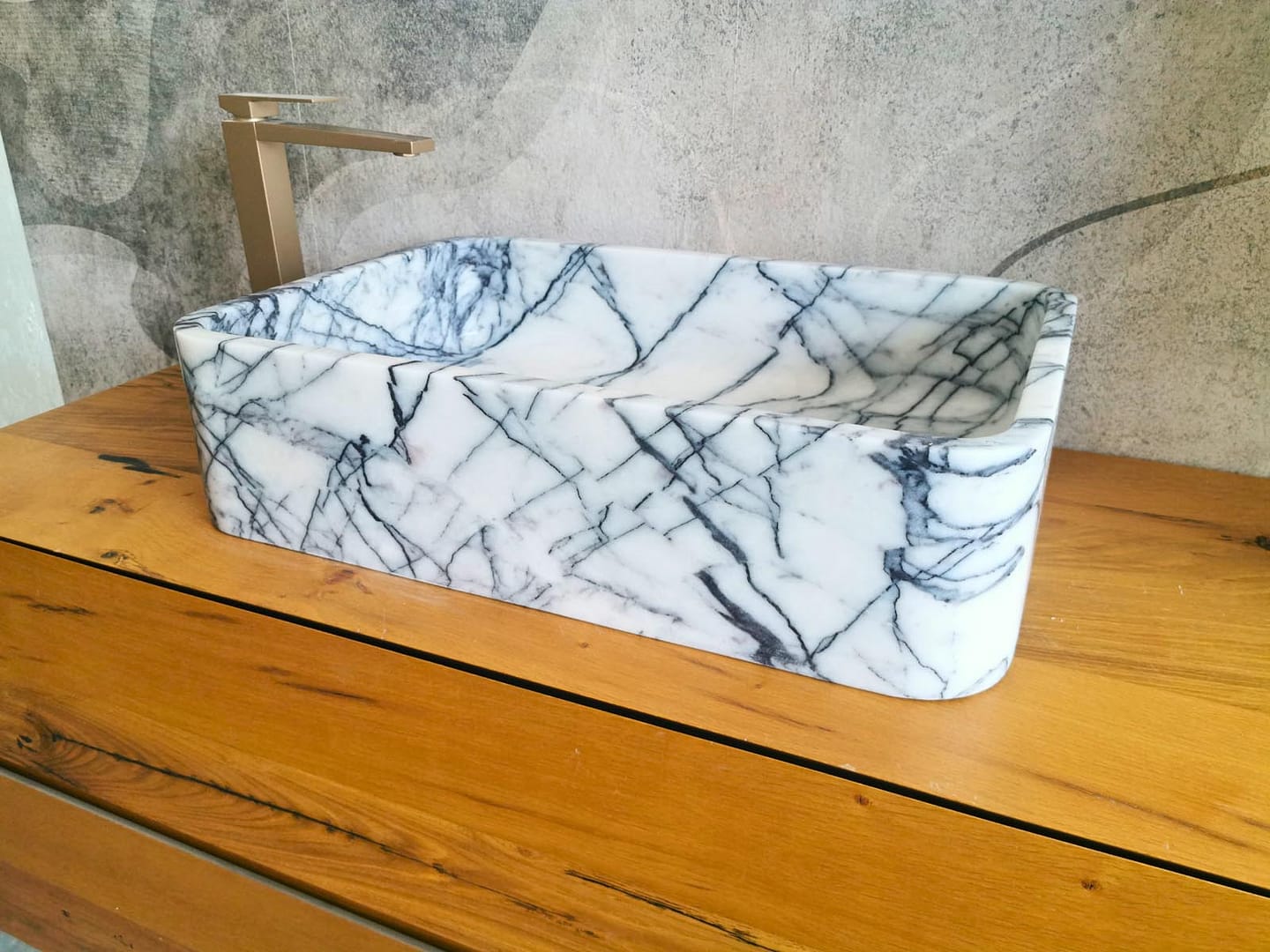 Lavabo in marmo Lilac ripreso di tre quarti, con forma rettangolare e angoli morbidamente arrotondati.