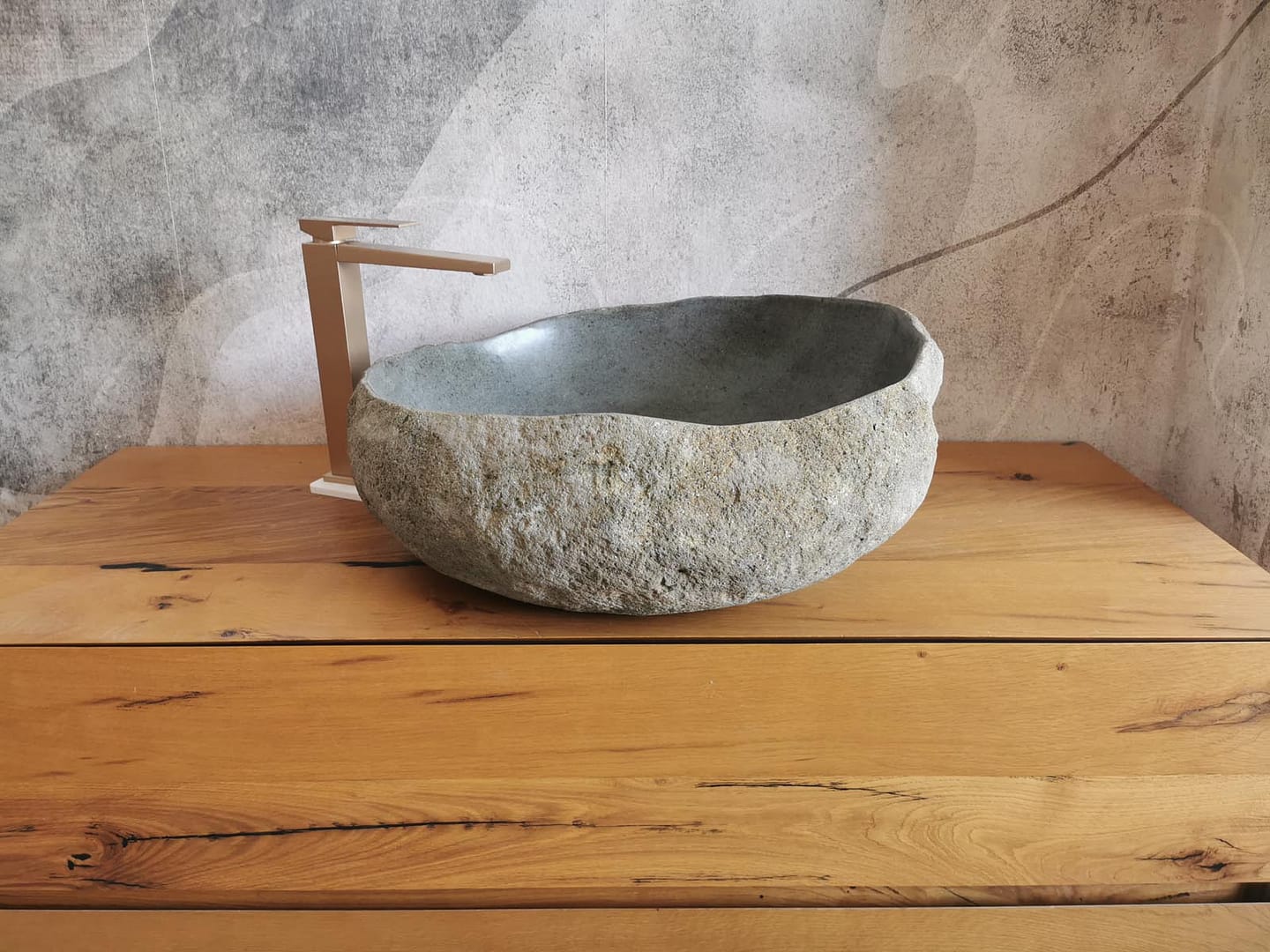 Foto reale di lavabi da appoggio in pietra di fiume, ideali per bagni rustici, naturali e ambienti dal carattere materico.