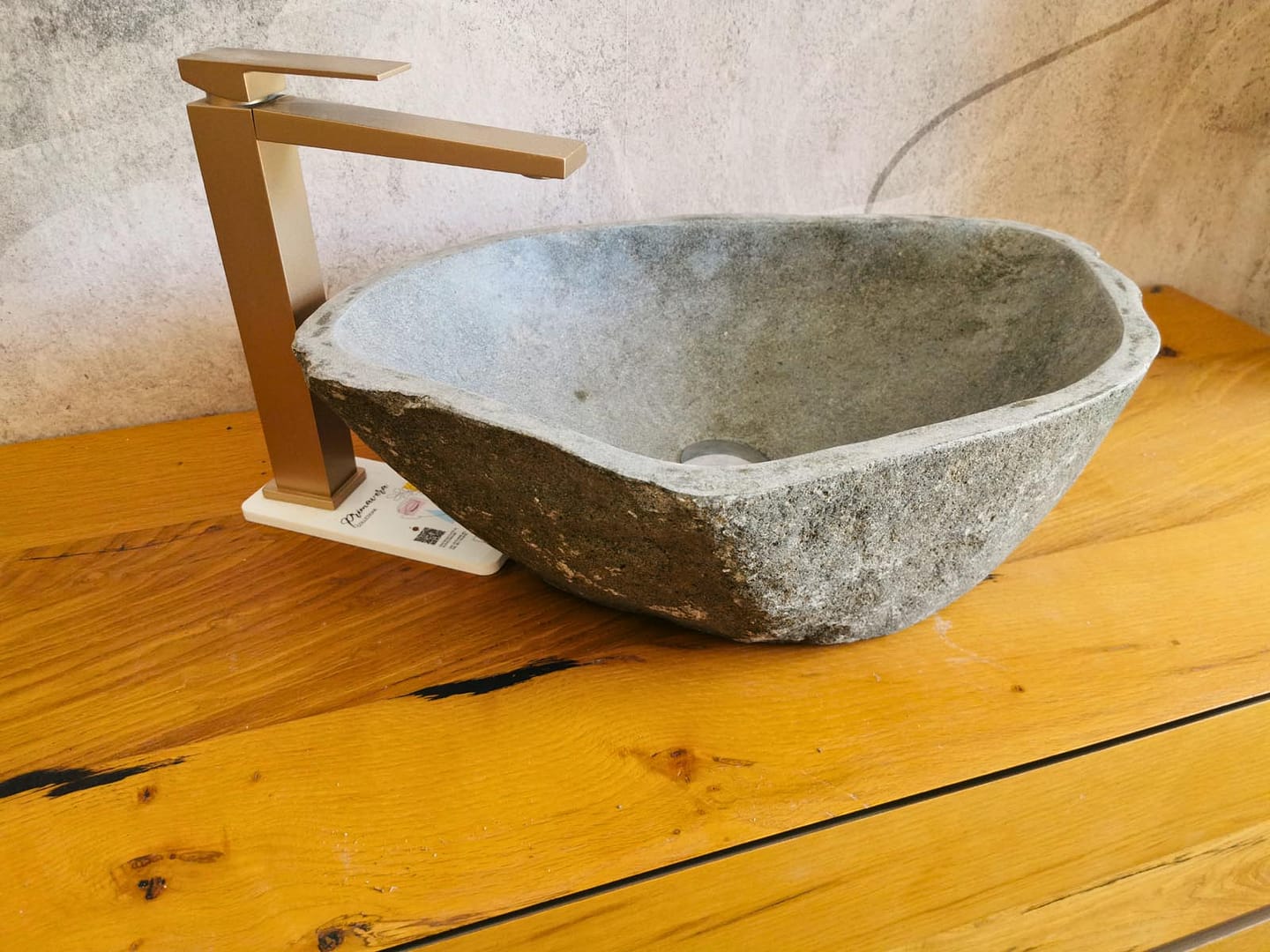 Foto reale di lavabo in pietra con finitura materica, adatto a bagni naturali, country o dal design essenziale.
