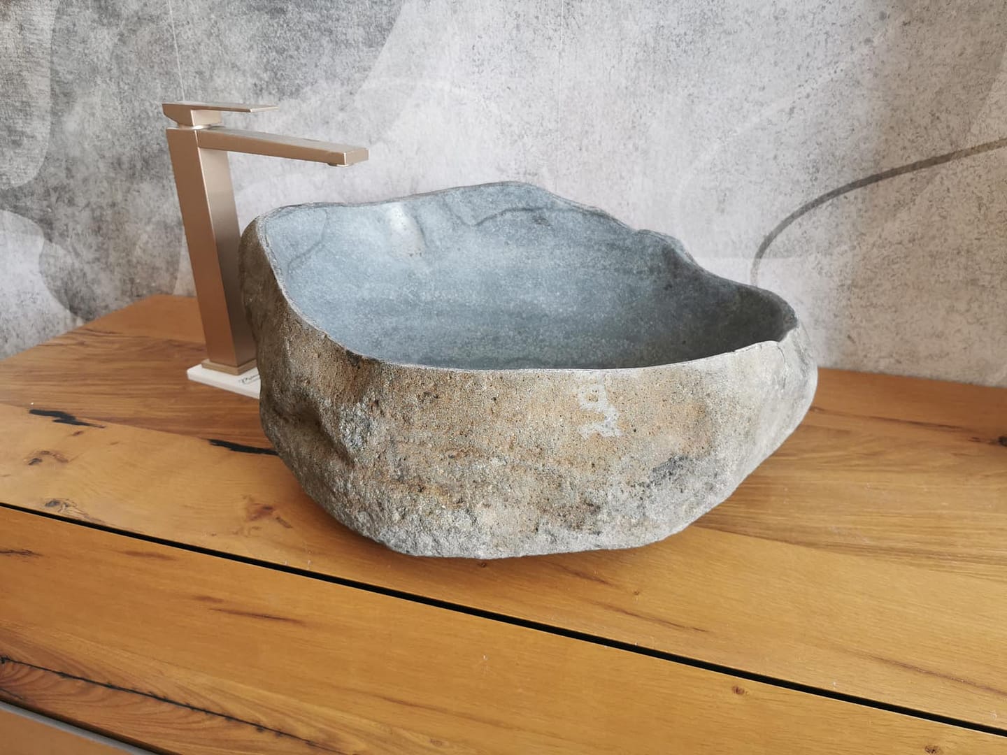 Immagine reale di lavabo in pietra di fiume da appoggio per arredo bagno rustico, materico e ricercato.